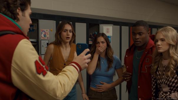 Image of young teens looking shock at something on a mobile phone